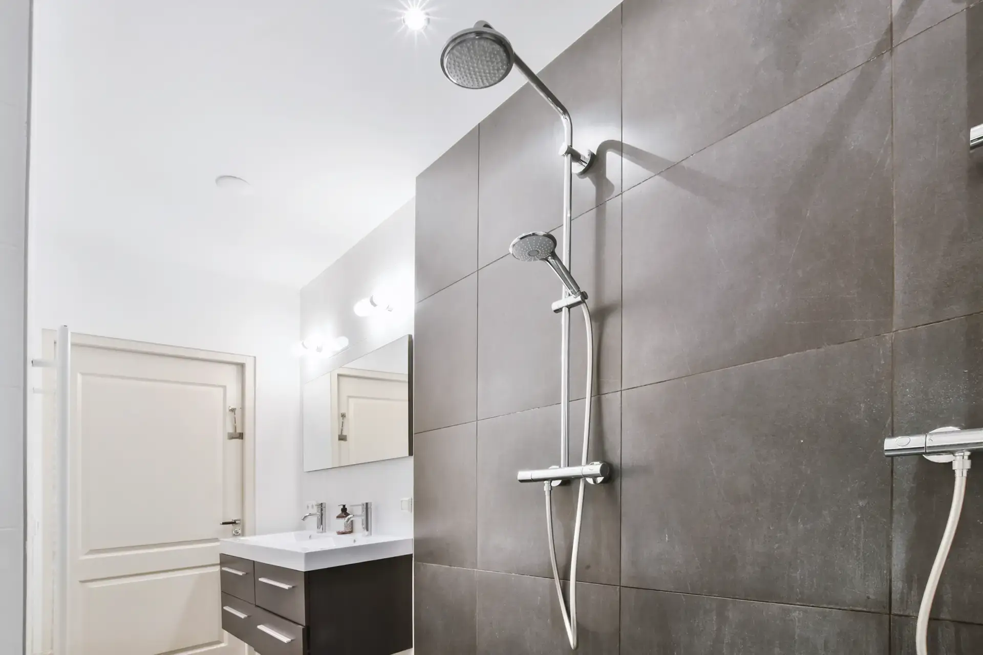 Horsens badeværelse med moderne bruser og elegant vægflise.